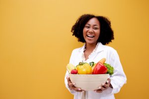 Portrait African American Positive dietitian with fruits and veg